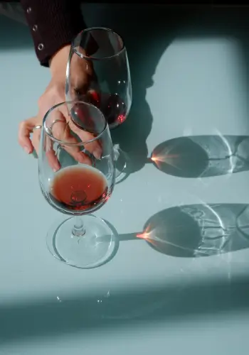 table with two glasses of Port Wine and a hand holding one of the glasses.